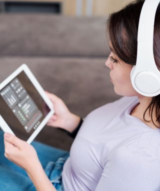 young-woman-in-headphones-looking-at-remote-4ZG96T5